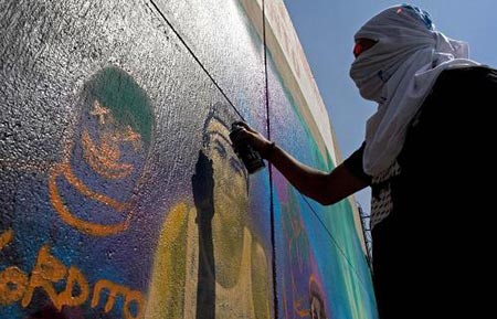 A man paints graffiti on a wall of the Azteca stadium during a graffiti contest in Mexico City February 15, 2009.[Xinhua/Reuters] 