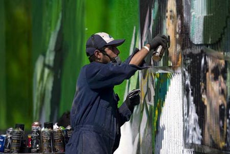  A man paints graffiti on a wall of the Azteca stadium during a graffiti contest in Mexico City February 15, 2009.[Xinhua/Reuters]