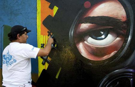 A man paints graffiti on a wall of the Azteca stadium during a graffiti contest in Mexico City February 15, 2009.[Xinhua/Reuters] 