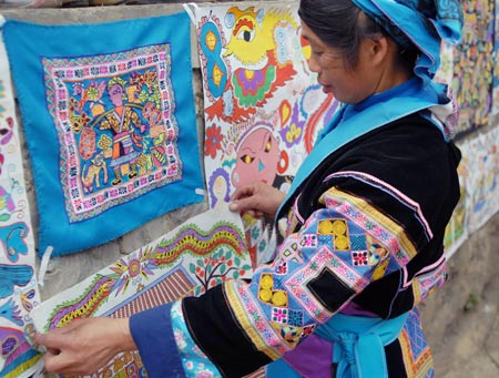 A woman of Miao ethnic group pastes her hand-made picture during a cultural activity held in Pingpo Village of Longli County, southwest China&apos;s Guizhou Province, Feb. 14, 2009. Local people of Miao ethnic group gathered here to celebrate an annual cultural activity on Saturday.