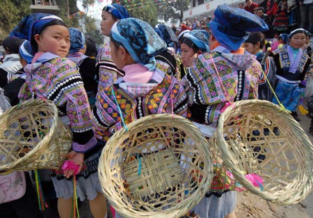Girls of Miao ethnic group watch the performances during a cultural activity held in Pingpo Village of Longli County, southwest China&apos;s Guizhou Province, Feb. 14, 2009. Local people of Miao ethnic group gathered here to celebrate an annual cultural activity on Saturday. (Xinhua/Ouyang Changpei)