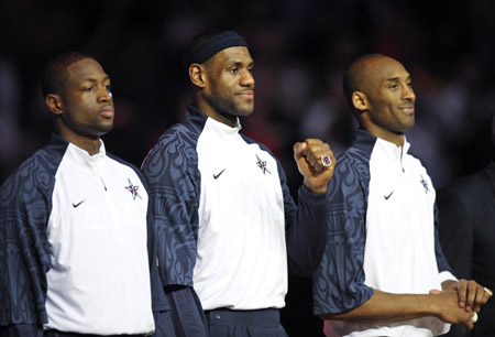 Cleveland Cavaliers' LeBron James (C), Miami Heat's Dwyane Wade (L) and Los Angeles Lakers' Kobe Bryant show their rings during a ceremony where they were presented rings for wining the gold medal at the Olympics in Beijing of China last year, during halftime at the NBA All-Star basketball game in Phoenix, Arizona of the United States, Feb. 15, 2009. [Xinhua]