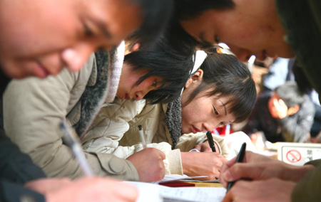 Chinese job hunters fill in application forms at a job fair for university graduates in rural Beijing Feb. 16, 2009. About 1.5 million university graduates in China failed to be employed by the end of the year of 2008 and another 6.11 million new graduates will seek jobs in the year of 2009 among the economic slump, worsening the government's endeavor to improve employment rate. [Bu Xiangdong/Xinhua]