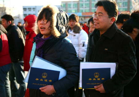 Two young Chinese with their diplomas queue up to enter a job fair for university graduates in rural Beijing Feb. 16, 2009. About 1.5 million university graduates in China failed to be employed by the end of the year of 2008 and another 6.11 million new graduates will seek jobs in the year of 2009 among the economic slump, worsening the government's endeavor to improve employment rate.Bu [Xiangdong/Xinhua]