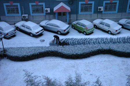 A resident living in Shijingshan district clears snow on the road in Beijing, capital of China, Feb. 17, 2009. Beijing welcomes its first snow after the Spring Festival.[Xinhua]