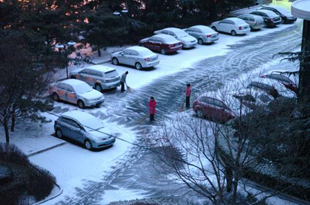 Residents living in Shijingshan district clear snow on the road in Beijing, capital of China, Feb. 17, 2009.[Xinhua]