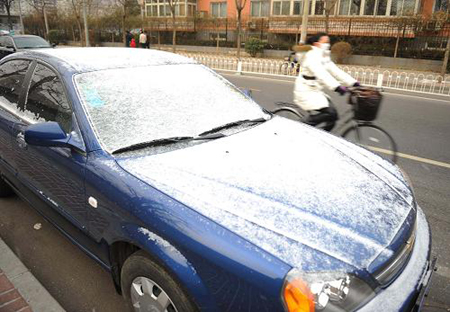 A car covered by snow is seen alongside a road in Beijing, capital of China, Feb. 17, 2009.[Xinhua]