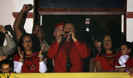 Venezuela's President Hugo Chavez celebrates with members of his government and family on a balcony of Miraflores Palace after the government announced their exit polls gave him a victory in a national referendum to decide whether to allow him to stay in power for as long as he keeps winning elections, February 15, 2009. [China Daily/Agencies]