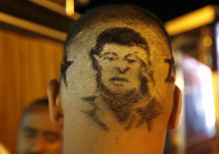 A supporter of Venezuelan President Hugo Chavez sports a haircut depicting the president as he waits for the results of a referendum outside Miraflores Palace in Caracas February 15, 2009. Chavez has won the referendum on lifting term limits to allow him to stay in power as long as he keeps winning elections, electoral authorities said on Sunday. [China Daily/Agencies]