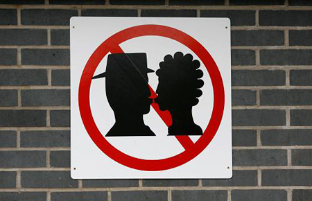 A No Kissing sign is displayed outside Warrington Bank Quay railway station in Warrington, northern England, February 16, 2009. The sign was erected at the drop off point after departing passengers and drivers blocked access to the station with their vehicles while saying goodbye to each other, local media reported.[Xinhua/Reuters]