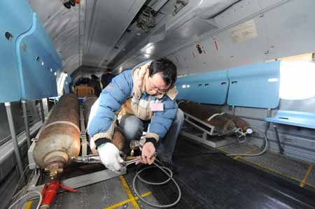 A crew member performs artificial rainfall operations on the aircraft over regions suffering from drought in central China's Henan Province, Feb. 8, 2009. A couple of 'Transport 7' aircraft of China's Air Force performed artificial rainfall operations in Huaibei of east China's Anhui Province, and Luoyang and Kaifeng of central China's Henan Province separately to relieve local drought on Sunday. [Xinhua]