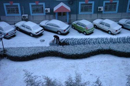A resident living in Shijingshan district clears snow on the road in Beijing, capital of China, Feb. 17, 2009. Beijing welcomes its first snow after the Spring Festival. [Xinhua] 