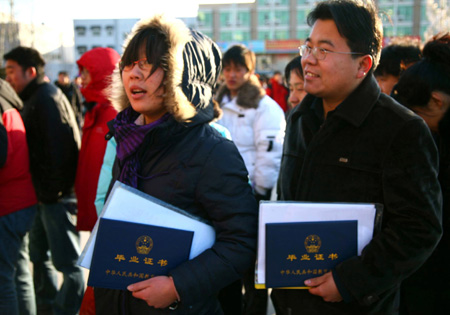 Two young Chinese with their diplomas queue up to enter a job fair for university graduates in rural Beijing Feb. 16, 2009. About 1.5 million university graduates in China failed to be employed by the end of the year of 2008 and another 6.11 million new graduates will seek jobs in the year of 2009 among the economic slump, worsening the government&apos;s endeavor to improve employment rate. (Xinhua/Bu Xiangdong)