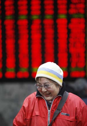 A woman smiles after watching stocks prices rise in a stock exchange market in Shanghai Feb. 16, 2009. China's benchmark Shanghai composite index on the Shanghai stock exchange closed at 2,389.39 points on Monday, up 68.6 points, or 2.96 percent, while the Sehnzhen component index closed at 8,771.04 points, or up 1.65 percent from the previous close. [Xinhua]
