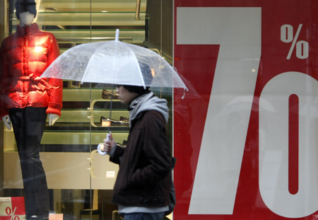 A man walks past a shop advertising a sale in Tokyo Jan. 30, 2009. The world's second largest economy is in the midst of its first recession in seven years as the global economic slowdown sharply reduced demand overseas for cars, electronics and other key exports. [Xinhua]