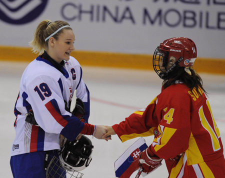Players of China and Slovakia exchange team flags before their women ice hockey preliminary, the first match at the 24th World Winter Universiade in the Harbin Ice Hockey Gym of Harbin, capital of northeast China&apos;s Heilongjiang Province, Feb. 18, 2009. (Xinhua/Zhou Que)