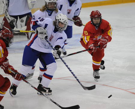 Players of China and Slovakia fight for the puck during their women ice hockey preliminary, the first match at the 24th World Winter Universiade in the Harbin Ice Hockey Gym of Harbin, capital of northeast China&apos;s Heilongjiang Province, Feb. 18, 2009. (Xinhua/Zhou Que)