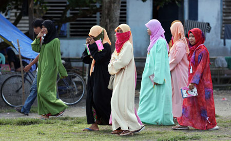 Evacuees walk inside evacuation camp in Datu Piang, Maguindanao province, the Philippines, Feb. 17, 2009. A 45-minute clash broke out between militants of the Moro Islamic Liberation Front (MILF) and the Philippine troops in the predominant Muslim zones in Maguindanao province, ignoring the appeal of a Brussel-based crisis group to both sides to lay down guns to discuss a ceasefire. The Red Cross were distributing relief to the people displaced in the area.[Xinhua]