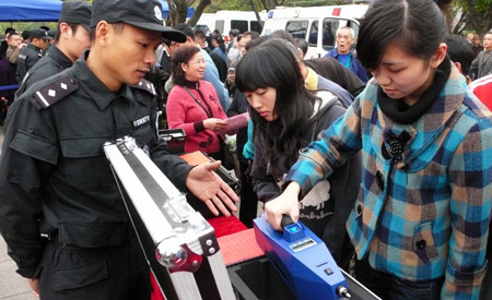 A Chinese police officer explains a set of explosive detecting instrument during a city show for local residents at a square in Liuzhou, southwest China's Guangxi Zhuang Autonomous Region, Feb. 17, 2009. [Li Bin/Xinhua]