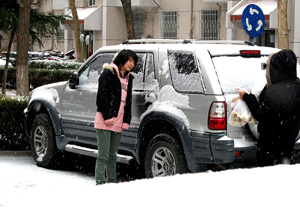 A girl takes photo in snow in Beijing, captial of China, Feb. 17. [Xinhua]