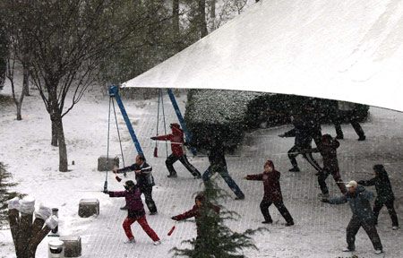 Local residents do morning exercises in snow in Beijing, capital of China, Feb. 17, 2009. The icy weather gripped the city on Tuesday morning. (Xinhua/Wang Mingli)