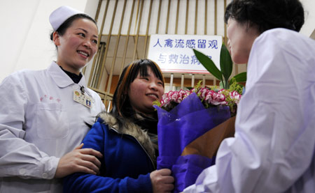 A bird flu patient surnamed Shu presents flowers to medical workers as she is leaving the Xiangya Hospital affiliated to Zhongnan University in Changsha, central China's Hunan Province, on Feb. 17, 2009. Shu was confirmed as infected with bird flu on Feb. 30, the first human case in Hunan Province. She recovered from the illness after 20-day treatment and left the hospital on Feb. 17. [Zhao Zhongzhi/Xinhua]