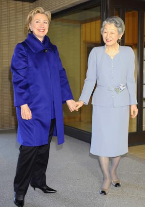 U.S. Secretary of State Hillary Clinton (L) smiles while holding hands with Japanese Empress Michiko upon Clinton's arrival for a tea party at the Imperial Palace in Tokyo, capital of Japan, Feb. 17, 2009. [Xinhua/Pool]