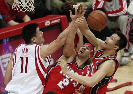 Houston Rockets center Yao Ming (L) battles for a rebound with New Jersey Nets center Josh Boone (2) and forward Yi Jianlian (R) during their NBA basketball game in Houston February 17, 2009. [Xinhua/Reuters]