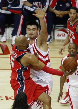  New Jersey Nets guard Vince Carter (L) puts up a shot under the arm of Houston Rockets center Yao Ming during their NBA basketball game in Houston February 17, 2009. [Xinhua/Reuters]