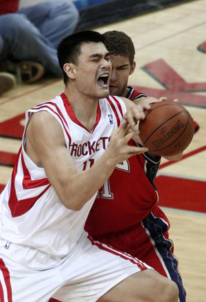 Houston Rockets center Yao Ming (L) yells as New Jersey Nets center Brook Lopez reaches in to knock the ball from his grasp during their NBA basketball game in Houston February 17, 2009.[Xinhua/Reuters]