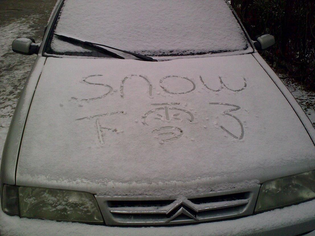 A snow-covered car bearing the inscription 'snow' by the roadside in Beijing on Feb.18.[Wu Huanshu/China.org.cn]