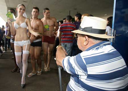 A model wearing underwear hands a sign to a man at a bus station during the third edition of the Brazilian version of the Underwear Day in Brasilia, Tuesday, Feb. 17, 2009. The Underwear Day was created in New York City in 2003. [Xinhua/AFP]