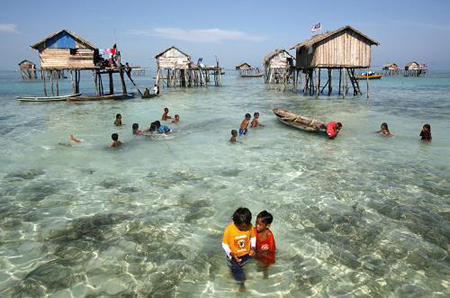 Young sea gypsies play in the water in the centre of their neighbourhood in the Sulawesi Sea in Malaysia's state of Sabah on the Borneo island February 17, 2009. A community of 30 families of the indigenous ethnic group of sea gypsies are still maintaining a nomadic and sea-based life without fresh water supply, TV nor electricity, and only go to land to bury the dead.[Xinhua/Reuters]