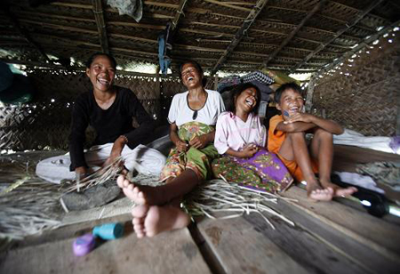 A family of sea gypsies laugh as they sit in their hut in the Sulawesi Sea in Malaysia's state of Sabah on the Borneo island February 17, 2009.[Xinhua/Reuters]