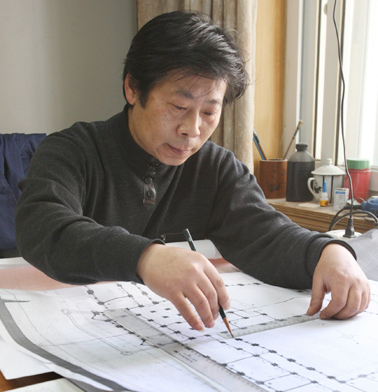 Guo Zhijun works on the blueprint of the model of the building at 320 Yueyang Road in Shanghai.