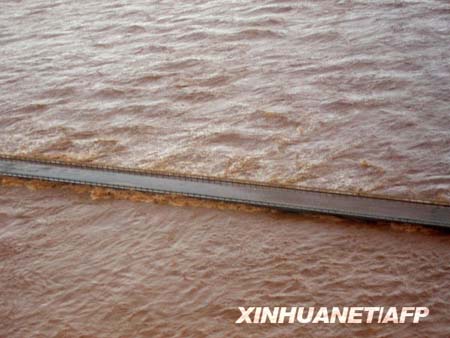 Flood waters lap at the edge of the Fortescue Bridge in the Pilbara Region in northern part of Western Australia state in this handout picture received February 18, 2009.([Xinhua/AFP]