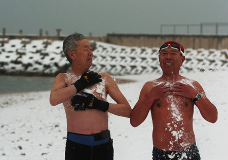 Two men do warm-up exercises with snow before swimming in Dalian, northeast China's Liaoning province on February 18, 2009. The snow on Wednesday coincided with 'Rain Water', one of the 24 solar terms according to Chinese luni-solar calendar, when it usually rains. Snow has eased the drought in north China. [Xinhua] 