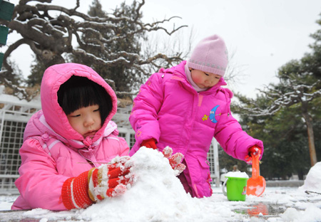 Two kids play with snow at Zhongshan Park in Beijing on February 18, 2009. The first snow this year began to fall on China's capital city Beijing in the wee hours of Tuesday, bringing with it joy to the city that had endured a long dry period. [Xinhua] 