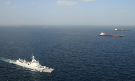 'Haikou' vessel of Chinese navy (front) escorts merchant vessels in the Gulf of Aden, on Feb. 17, 2009. The Chinese naval fleet completed its 21th batch of escort missions against pirates on Wednesday.[Zhu Hongliang/Xinhua] 