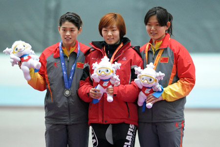 Lee Sang Hwa (C) of South Korea shows the mascot Dong Dong of the game with China's Yu Jing (L) and Zhang Shuang during the awarding ceremony of women's 500m speed skating finals at the 24th World Winter Universiade in the Heilongjiang Speed Skating Gym of Harbin, capital of northeast China's Heilongjiang Province, Feb. 19, 2009. Lee Sang Hwa claimed the title in the event, the first gold medal of the Winter Universiade. Yu and Zhang took the silver and bronze respectively. [Liu Dawei/Xinhua]