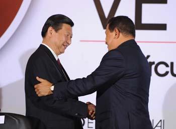 Chinese Vice President Xi Jinping (L) shakes hands with Venezuelan President Hugo Chavez at a business seminar in Caracas, Venezuela, Feb. 17, 2009. [Huang Jingwen/Xinhua] 