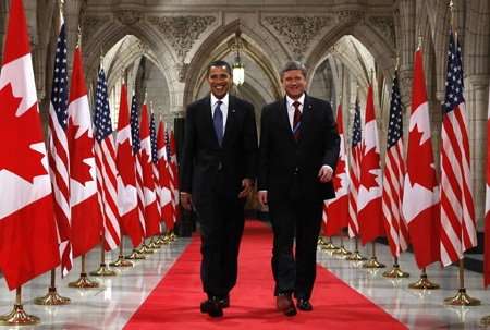 US President Barack Obama (L) and Canadian Prime Minister Stephen Harper walk down the Hall of Honour on the way to a news conference on Parliament Hill in Ottawa, February 19, 2009. [Agencies]