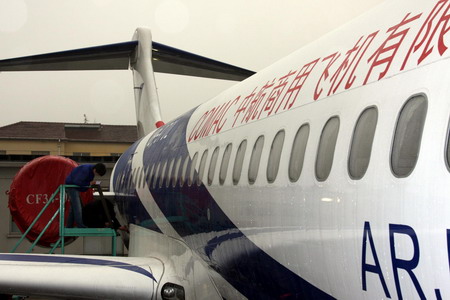 A worker checks an ARJ21 jet in Shanghai, Thursday Februray 19, 2009. The Commercial Aircraft Corporation of China has begun mass production of the country's first domestically developed regional jet ARJ21-700 for 208 orders from foreign and domestic customers. [Xinhua]