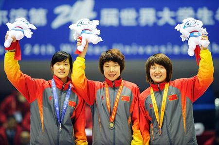 China's Zhou Yang (C), Liu Qiuhong (L) and Sun Linlin smile during the awarding ceremony for the women's 1500m short track speed skating finals at the 24th World Winter Universiade in Harbin, capital of northeast China's Heilongjiang Province, Feb. 19, 2009. Zhou took the gold medal of the event. Liu won the silver medal while Sun got the bronze. [Guo Dayue/Xinhua]