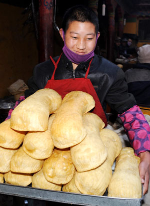 A Tibetan lama prepares a kind of traditional fried cake at a lama temple in Lhasa, capital of southwest China's Tibet Autonomous Region, Feb. 19, 2009. [Xinhua]