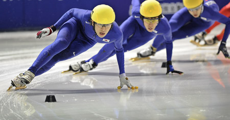 Lee Seung Hoon (L) of South Korea competes during the men's 1500m short track speed skating finals at the 24th World Winter Universiade in the Harbin University of Science and Technology Skating Gym of Harbin, capital of northeast China's Heilongjiang Province, Feb. 19, 2009. Lee claimed the title in the event with 2 minutes and 18.016 seconds. [Guo Dayue/Xinhua]