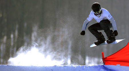 Russia's Vitaly Kartsev competes during the qualifications of men's snowboard cross in the 24th World Winter Universiade at the Maoershan Ski Resort, 85km southeast from Harbin, capital of northeast China's Heilongjiang Province, Feb. 20, 2009. Vitaly Kartsev took the 11th place after the qualifications with 1:01.73. 