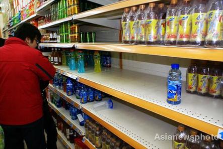 A customer looks at a half-empty shelf of bottled water in a supermarket in Yancheng, Jiangsu province, Friday, Feb 20, 2009. The price of bottled water has shot up because of the increasing demand.  [Photo: Chinadaily.com.cn/Asianewsphoto]