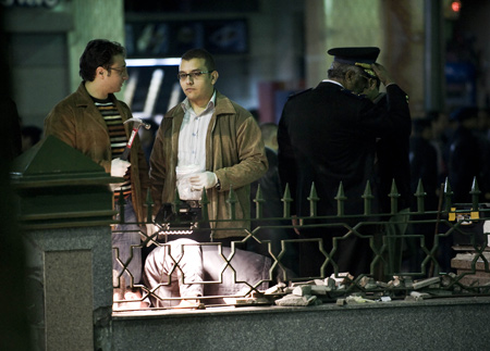 Egyptian policemen collect evidence in the blast scene located between the al-Hussein mosque and the Khan al-Khalili bazaar in Cairo, capital of Egypt, Feb. 22, 2009. [Zhang Ning/Xinhua]