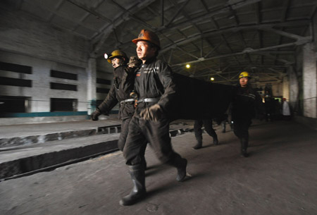 Rescue workers carry a body of a victim at a coal mine in north China's Shanxi Province, Feb. 22, 2009. 